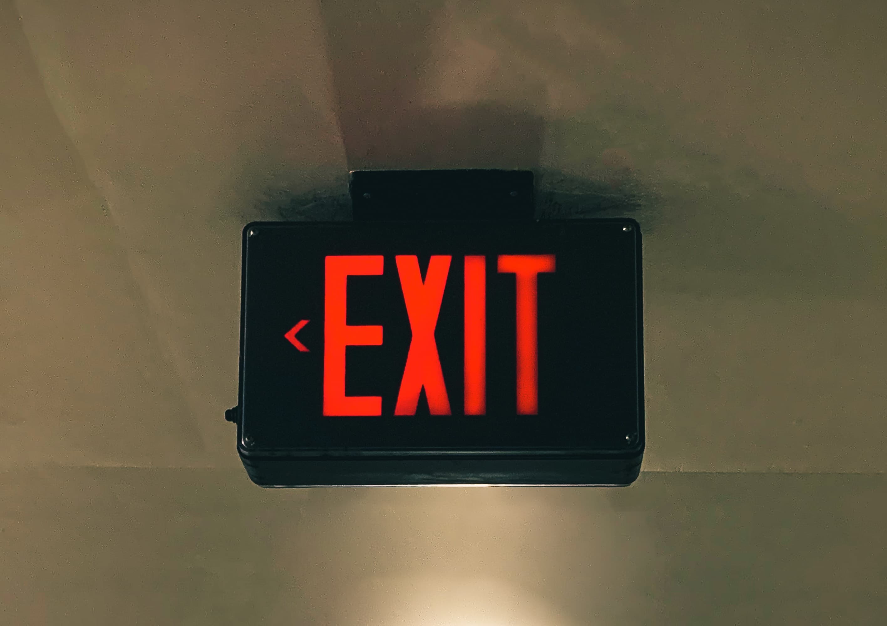 Black exit sign with red text on the roof thats electronic