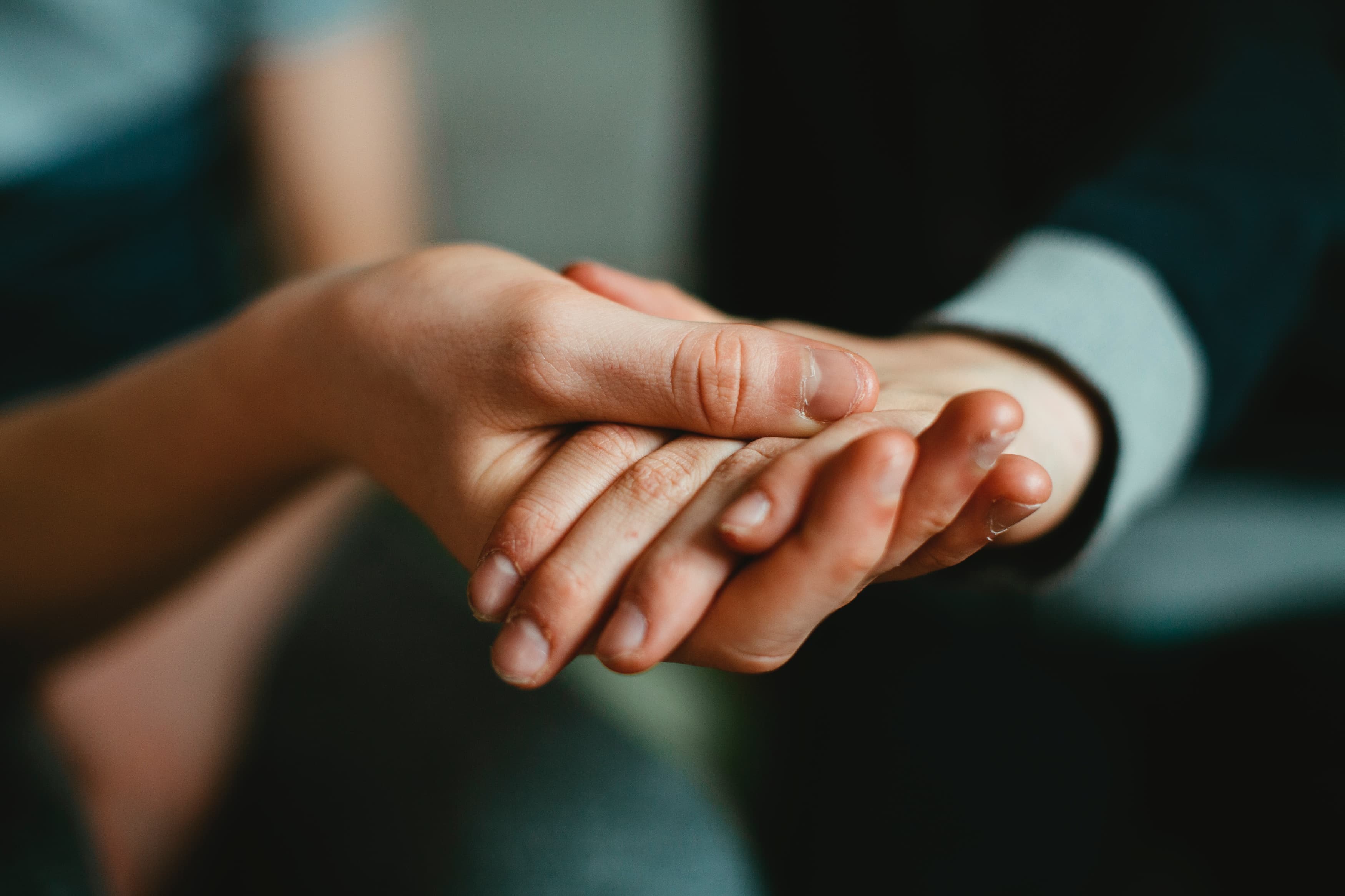 Two people holding each others hands to help each other